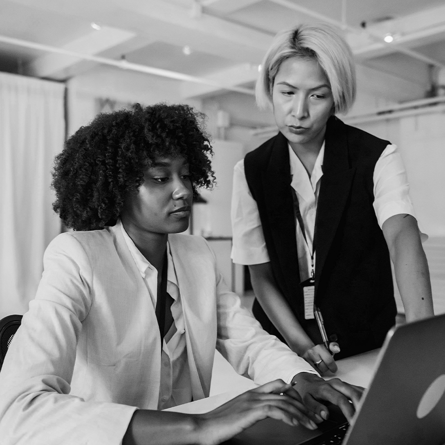 Female asian mentor looking over female black student